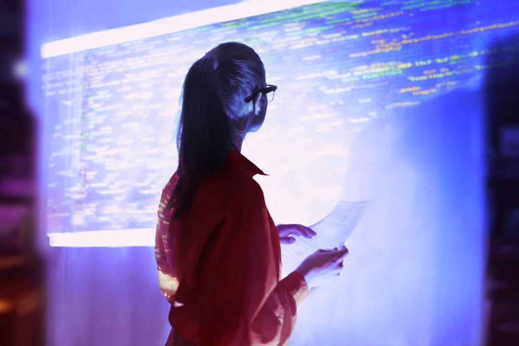 brand image - Woman looking at a wall projection of a digital code.