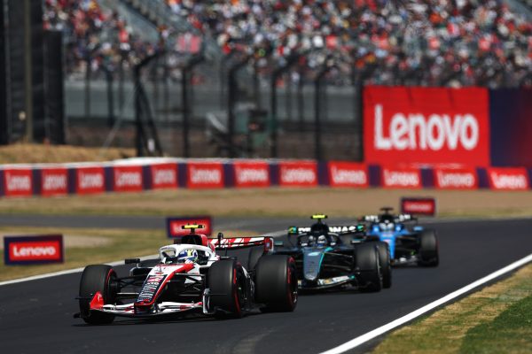 Formula 1 cars on the track with Lenovo logos in back.