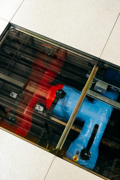 Red and Blue pipes below a glass tile in a floor