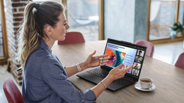 Woman sitting with a Lenovo ThinkPad, giving a presentation