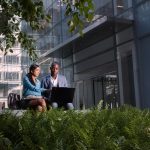 Colleagues using a Lenovo ThinkPad outside an office building