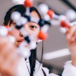 A woman working on molecule structure in a labcoat